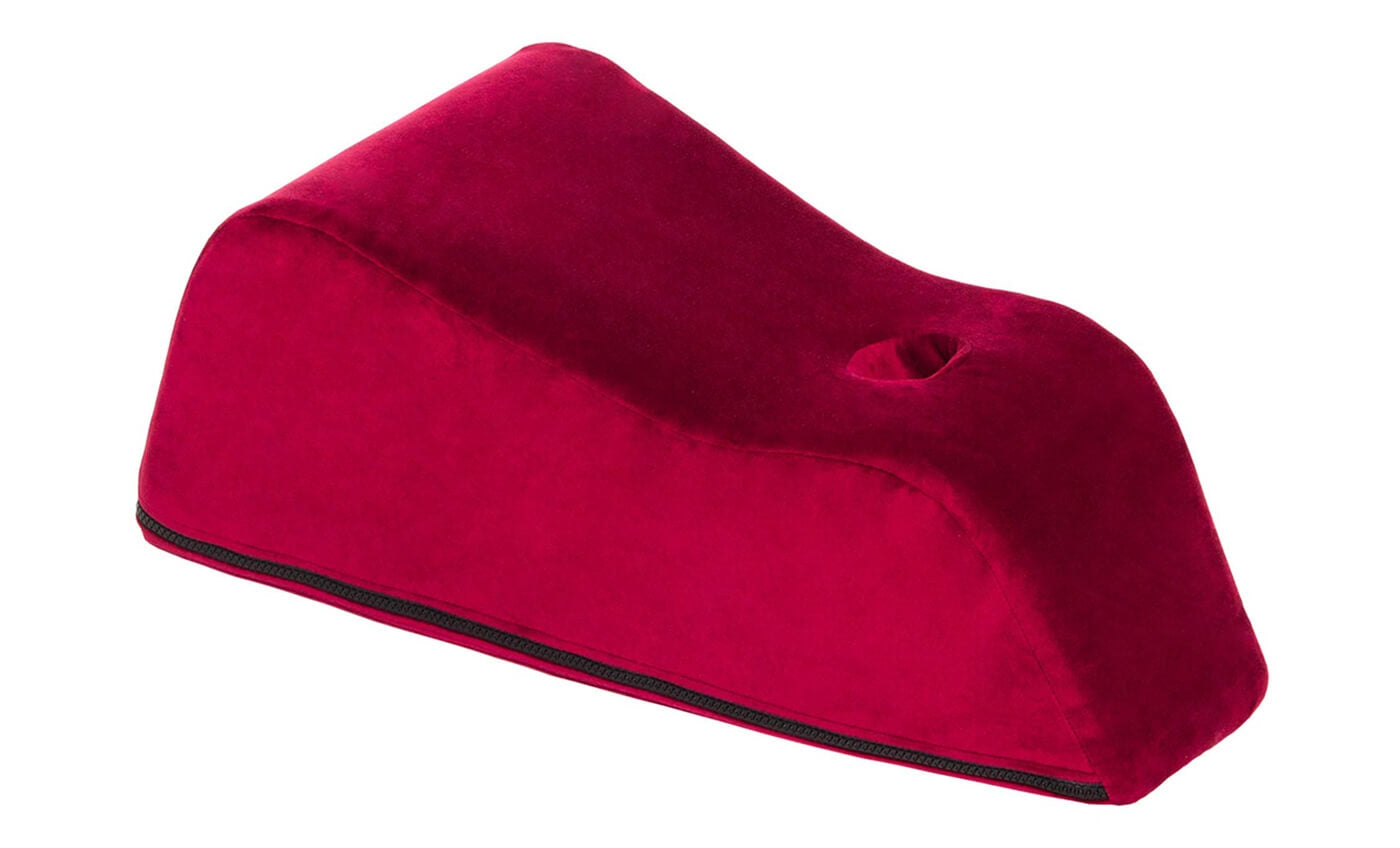 A red velvet wand toy mount with a curved shape and a hole.