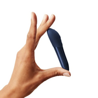 A hand holds a midnight blue vibrator.