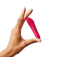 A hand holds a cherry red vibrator.