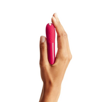A hand holds a cherry red vibrator with two buttons.