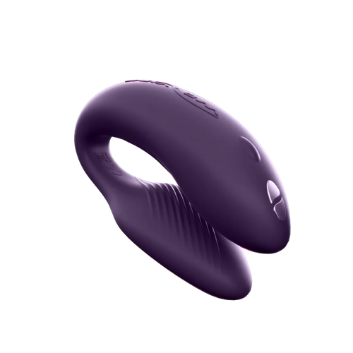 Purple couples vibrator with a curved shape and textured inner surface.