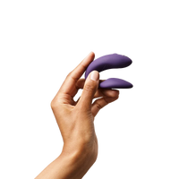 Purple couples vibrator held in a hand.