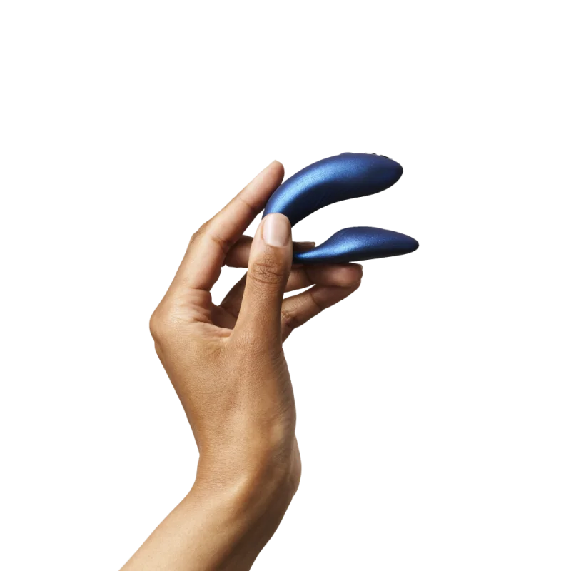 A hand holds a blue couples vibrator.