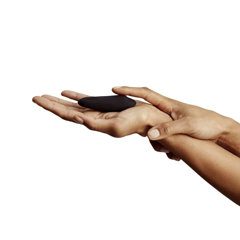 A black remote-controlled panty vibrator held in two hands.