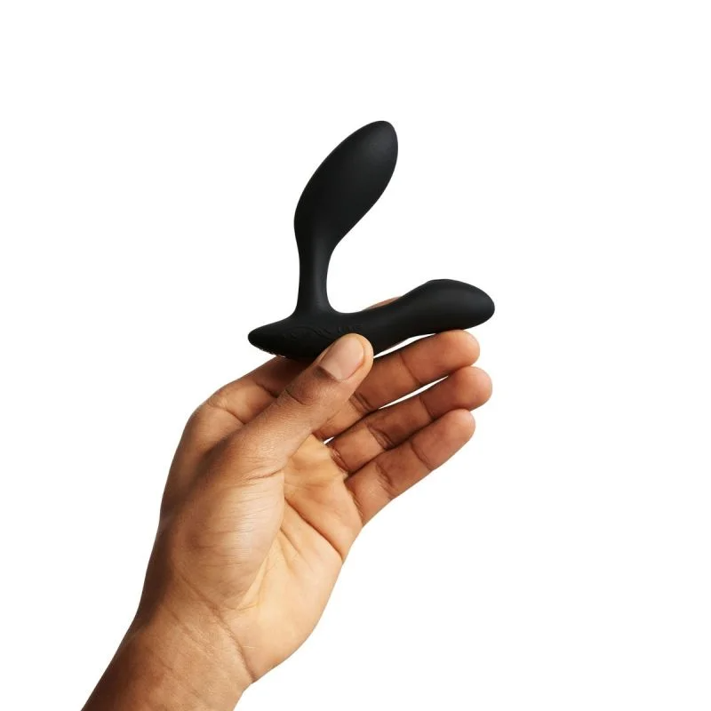 Black dual stimulation vibrator held in a hand.