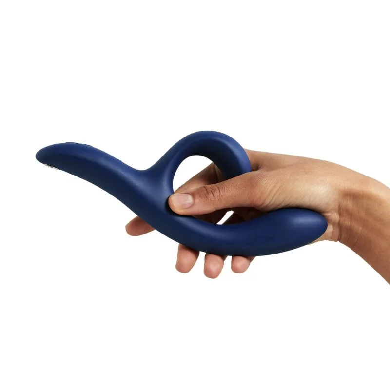 A hand holds a dark blue, curved vibrator with a loop.