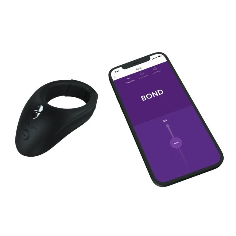 Black app-controlled wearable stimulation ring next to a smartphone displaying the app.