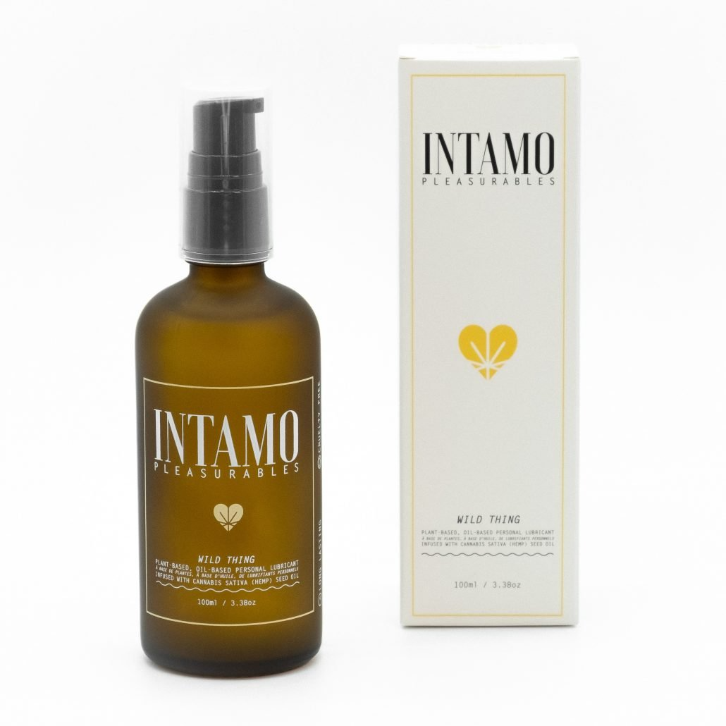 A brown glass bottle of Intamo Wild Thing oil-based personal lubricant with a pump dispenser, next to its white packaging.