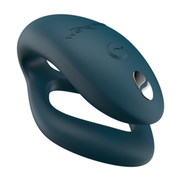 A dark teal We-Vibe Sync O couples vibrator with a remote control button.