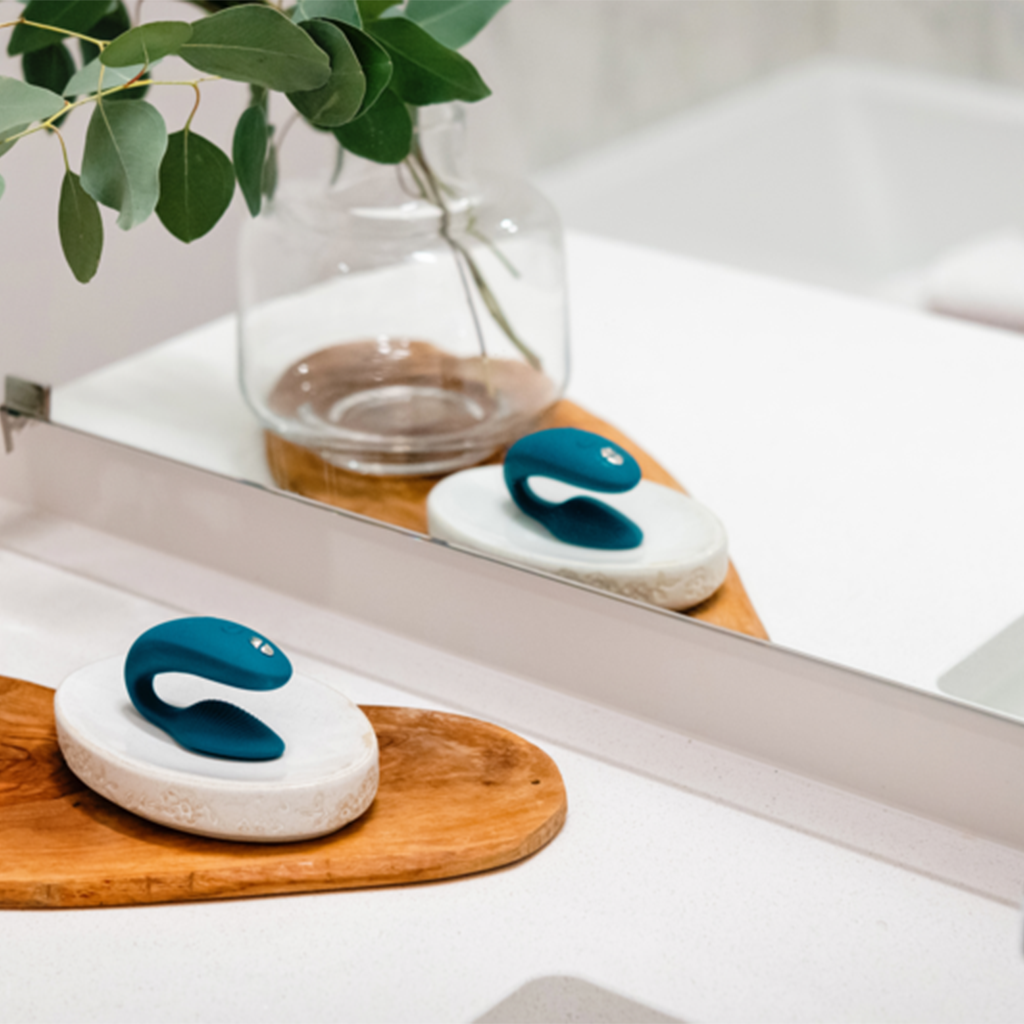 A green velvet app-controlled couples vibrator on a white dish.