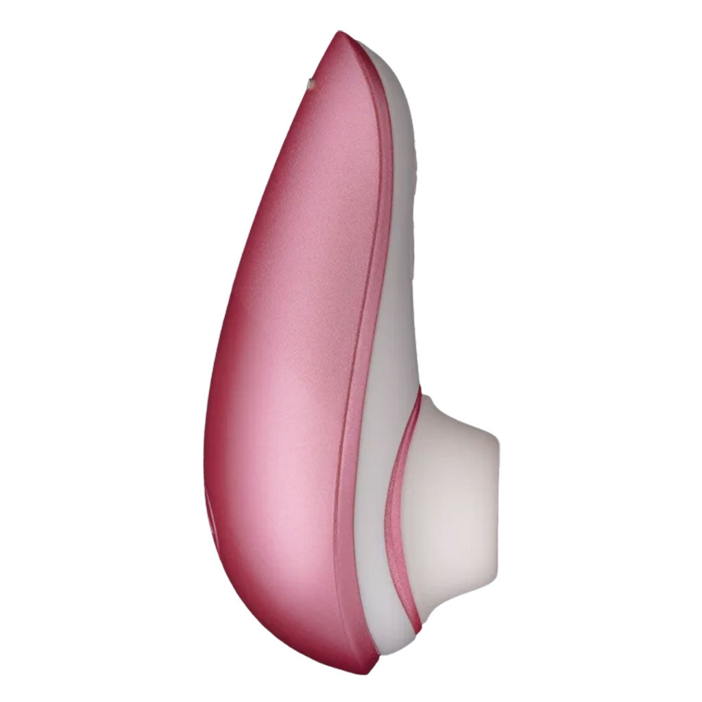 Pink and white Womanizer clitoral stimulator with a curved shape.