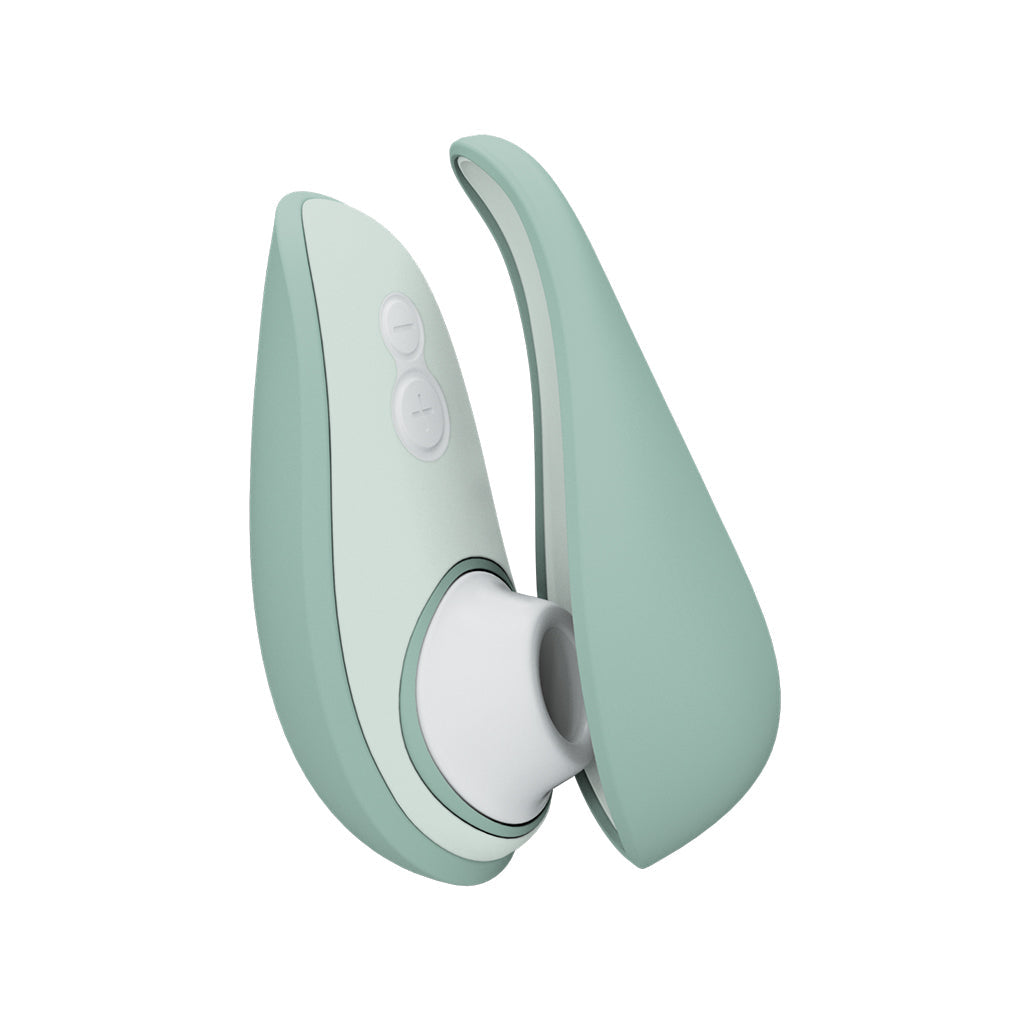 A sage green Womanizer Liberty 2 air stimulator with two buttons and a white opening.
