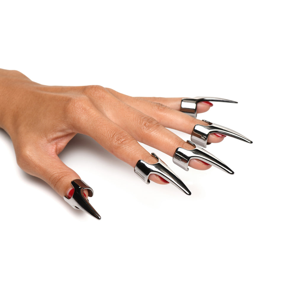 Five stainless steel claw rings on a hand with red nail polish.