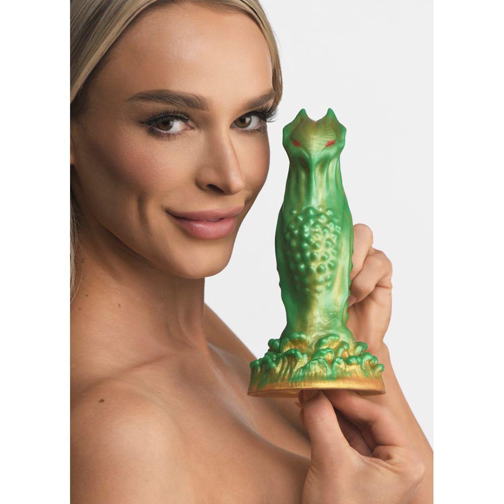 Green and gold alien dildo with red eyes and textured body.