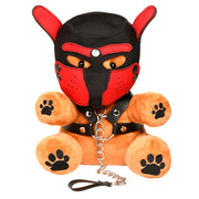 A plush teddy bear wearing a black and red pup hood, harness, and leash.
